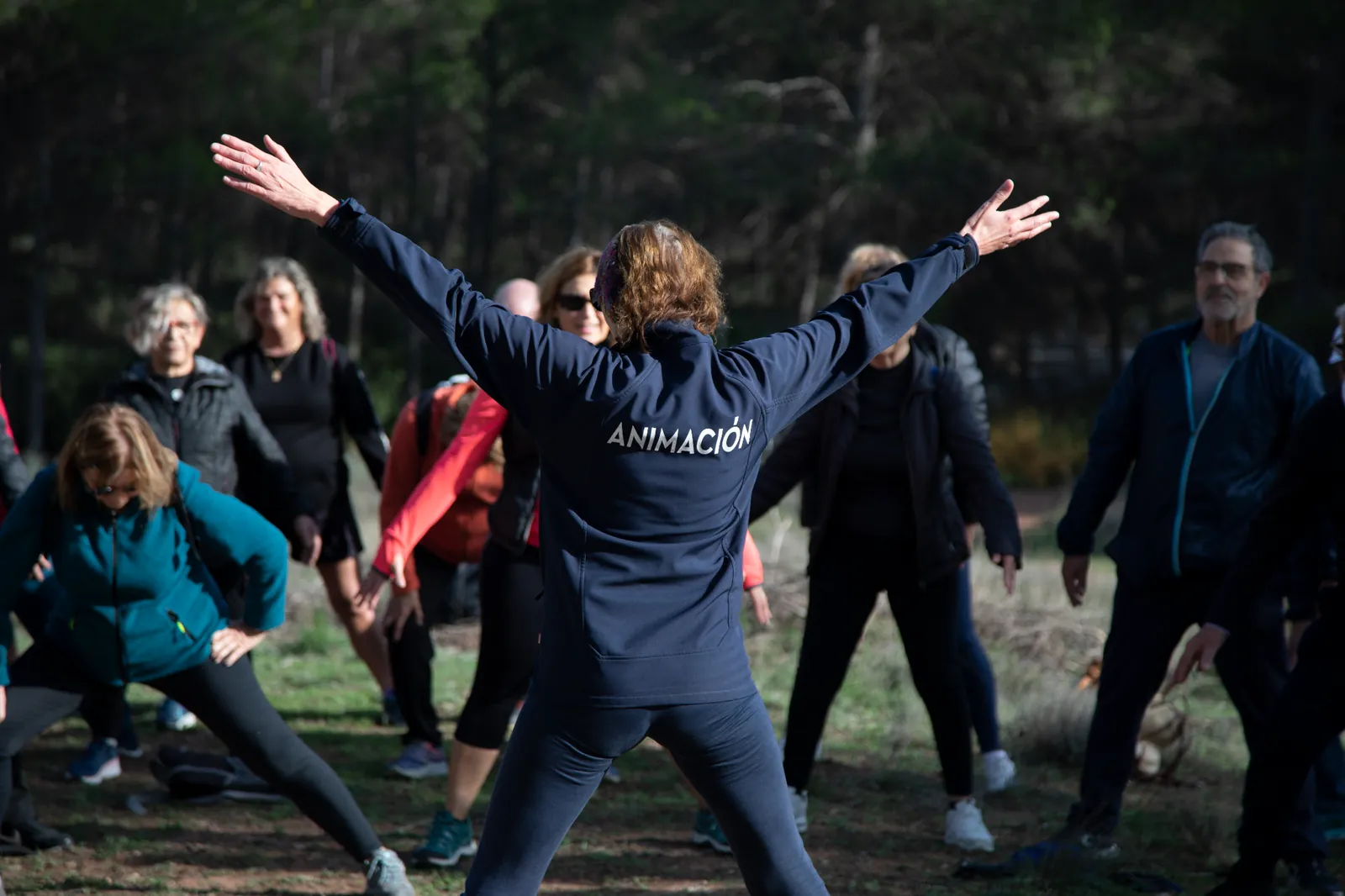 Grupo realizando ejercicios con el equipo de animación en el bosque